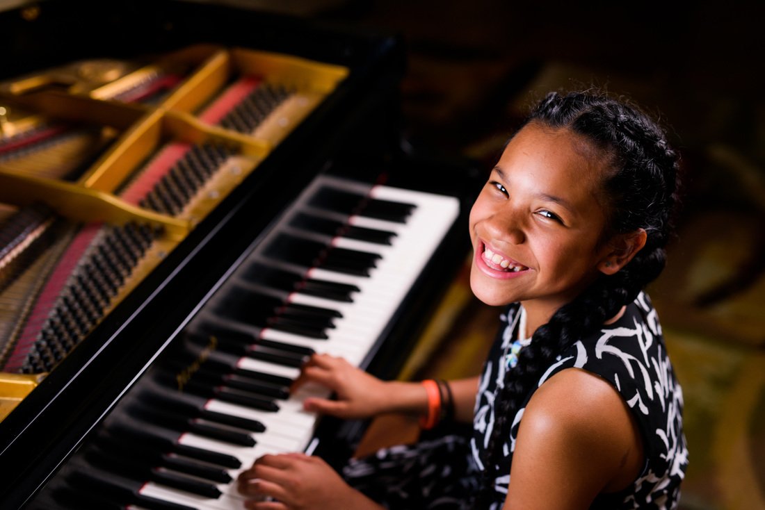 She is playing piano. Клавишные девочки. Девушка играет на пианино в торговом центре. Замкнутая девочка играет на пианино. Посадка ребенка за пианино.